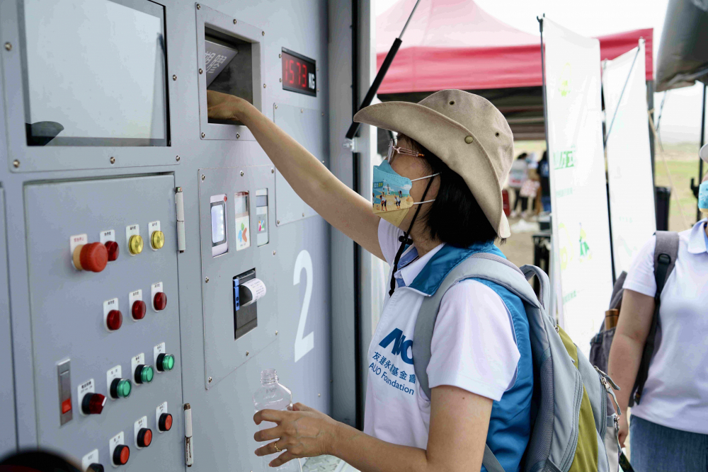 志工們將拾起的寶特瓶投入「好歸塑專車」，讓廢棄塑料空瓶可以直接粉碎、縮小體積，未來將可再製成購物袋、寶特衣、悠遊卡等生活用品